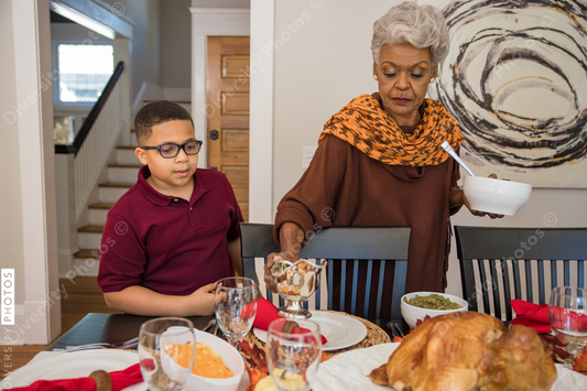 Black multigenerational family setting table for Thanksgiving  holiday meal