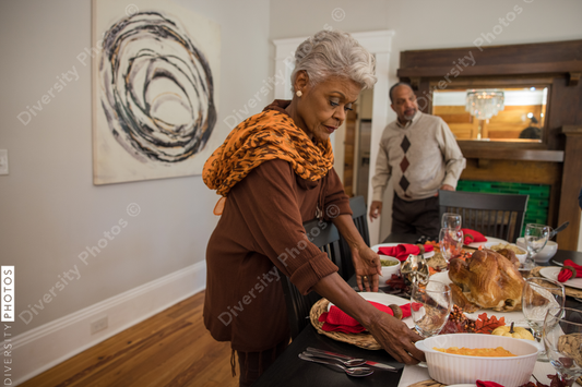 Black multigenerational family setting table for Thanksgiving  holiday meal