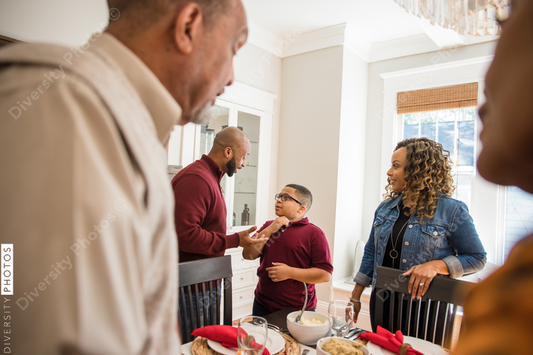 Black multigenerational family setting table for Thanksgiving  holiday meal