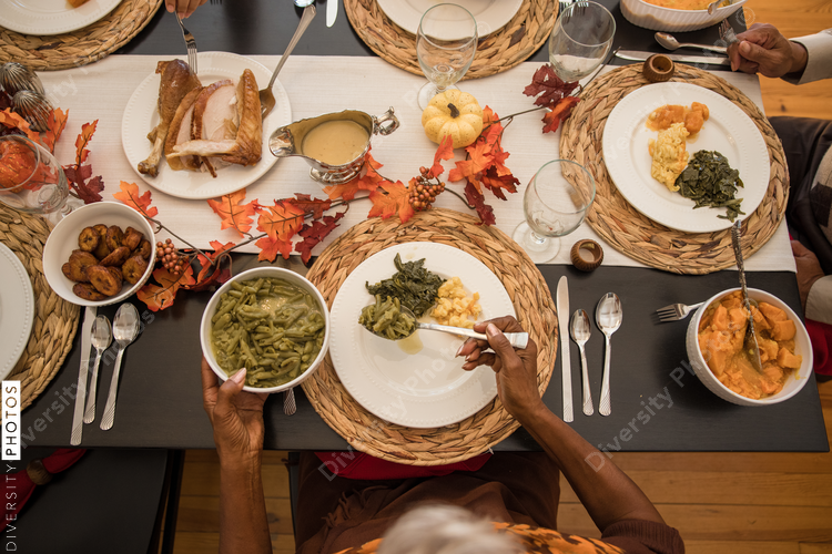 Overhead view of black hands eating Thanksgiving holiday meal