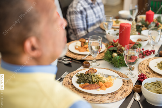 Black family eating Christmas dinner together at dining room table