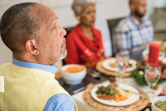 Black family eating Christmas dinner together at dining room table