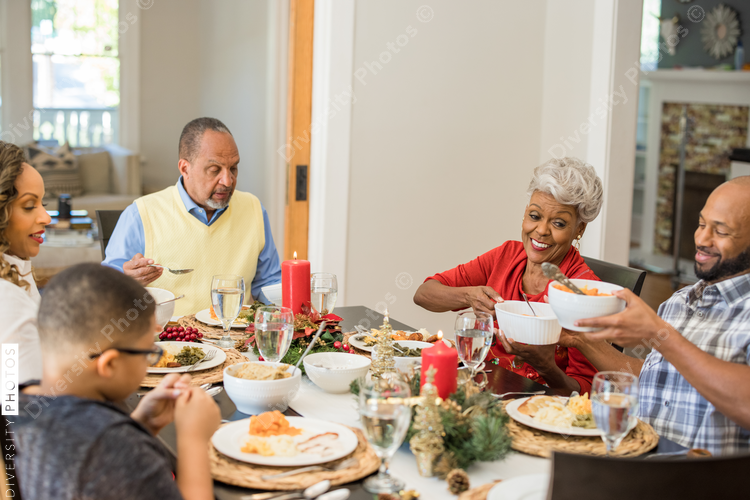 Black family eating Christmas dinner together at dining room table