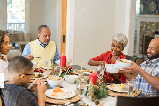 Black family eating Christmas dinner together at dining room table