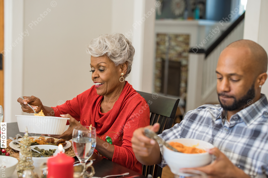 Black family eating Christmas dinner together at dining room table