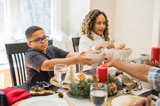 Black family eating Christmas dinner together at dining room table