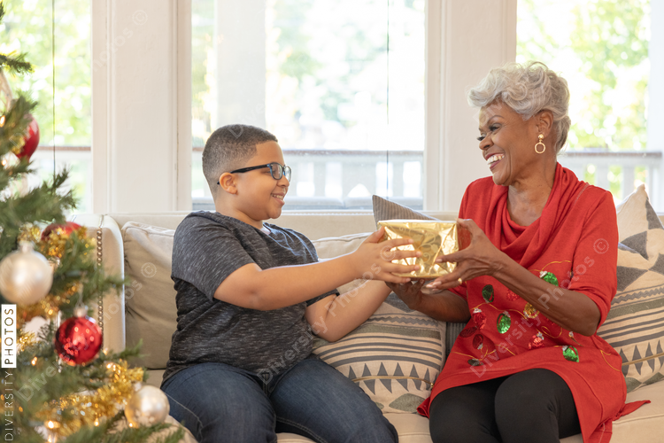 Grandmother and grandson sharing Christmas gifts at home
