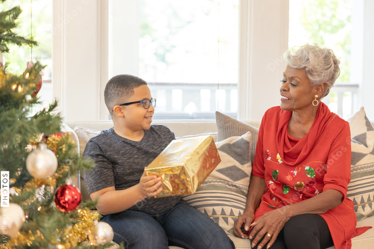 Grandmother and grandson sharing Christmas gifts at home