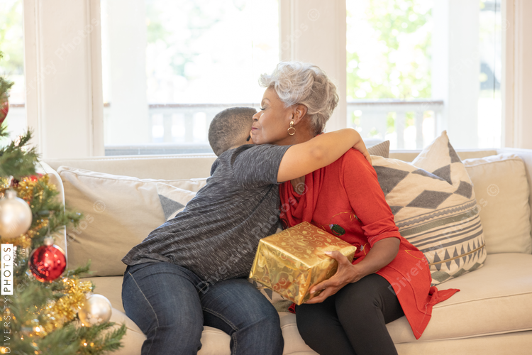 Grandmother and grandson sharing Christmas gifts at home