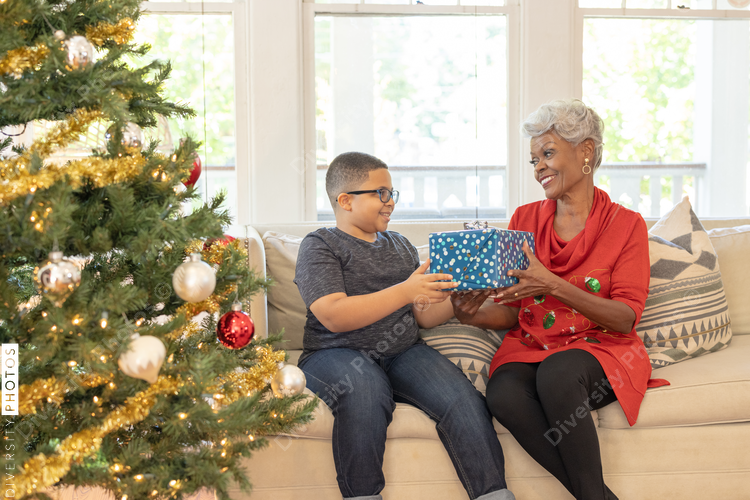 Grandmother and grandson sharing Christmas gifts at home