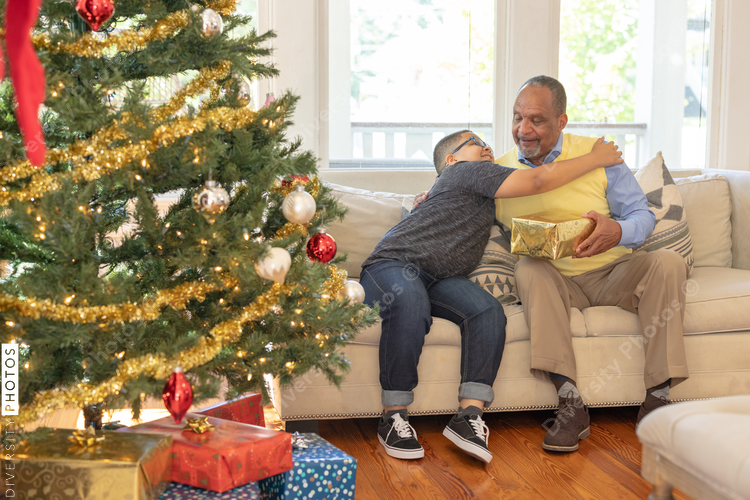 Grandfather and grandson sharing Christmas gifts at home