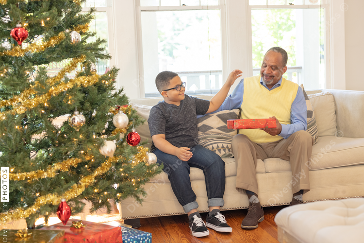 Grandfather and grandson sharing Christmas gifts at home