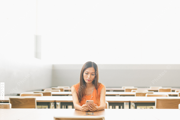 Young woman using cell phone indoors