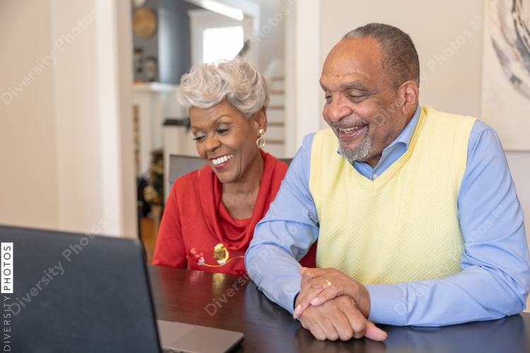 Grandmother and grandfather having a video chat on laptop at home for Christmas