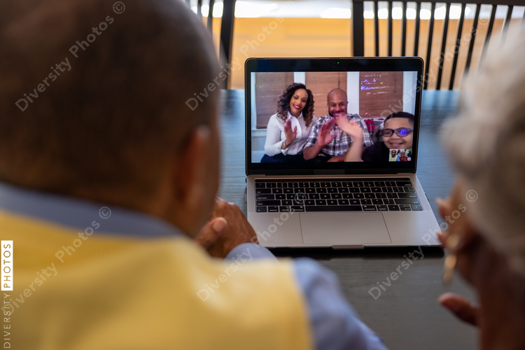 Grandmother and grandfather having a video chat  with family on laptop at home for Christmas