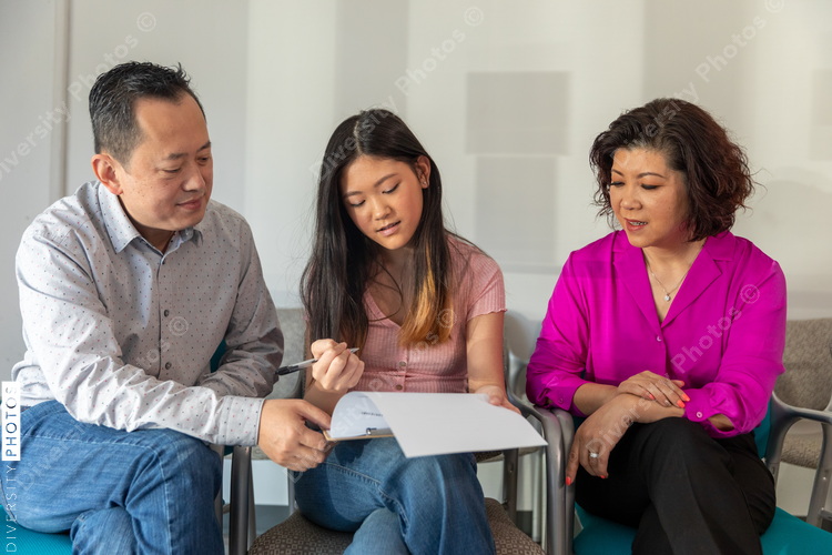 Chinese family waits in doctors office lobby completing translated forms