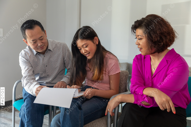 Chinese family waits in doctors office lobby completing translated forms