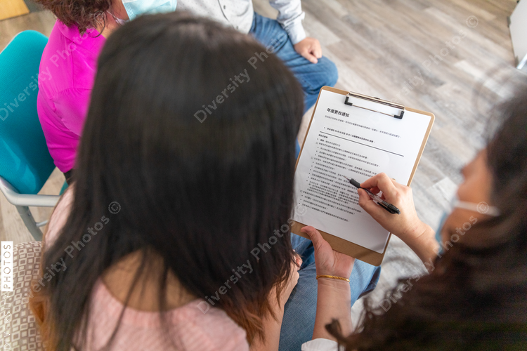 Doctor explains form to Asian family in waiting room