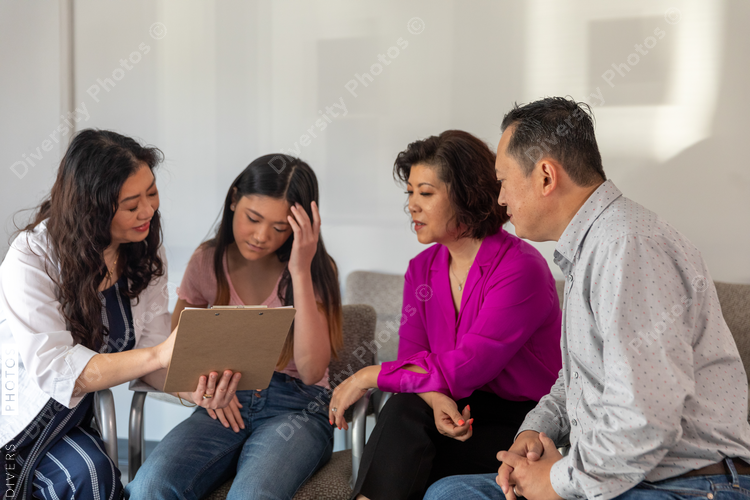 Doctor explains form to Asian family in waiting room