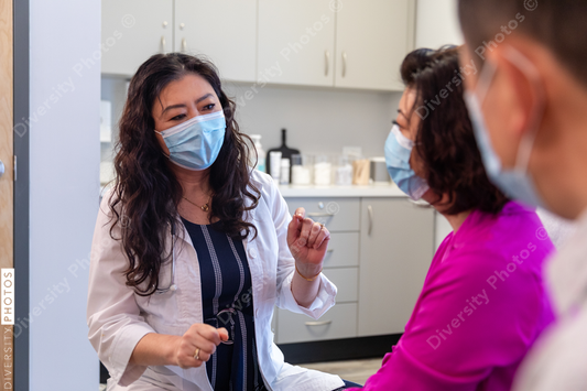 Asian doctor consulting patients in medical exam room