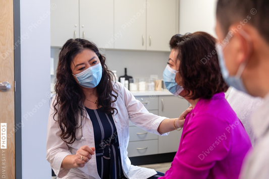 Asian doctor consulting patients in medical exam room
