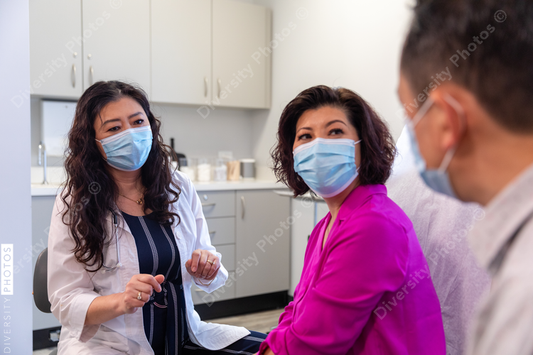 Asian doctor consulting patients in medical exam room