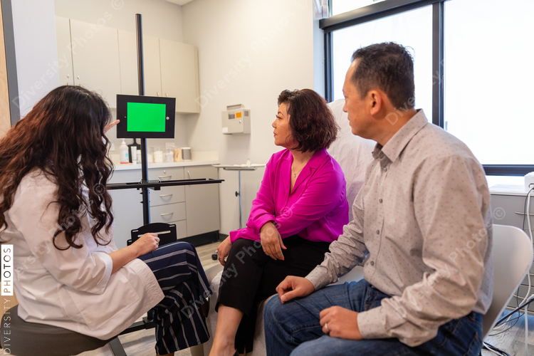Telehealth and remote translation professional consults patients in medical exam room