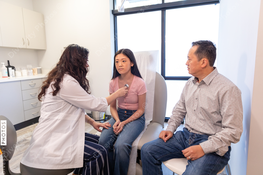 Asian doctor checks patient heartbeat using stethoscope