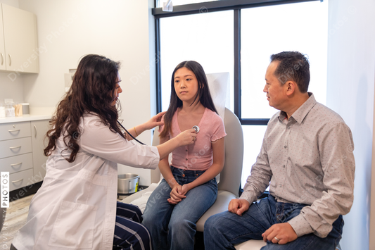 Asian doctor checks patient heartbeat using stethoscope