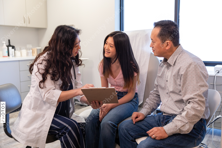 Doctor explains test results to young patient and her father
