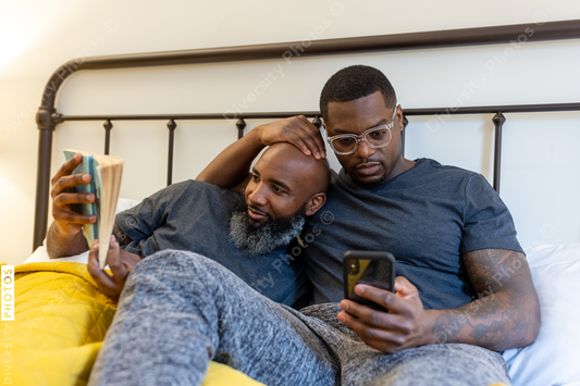 Black couple cuddling in bed at home, LGBTQ pride love connection