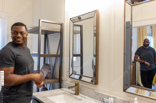 Black couple talking in bathroom while partner prepares for work
