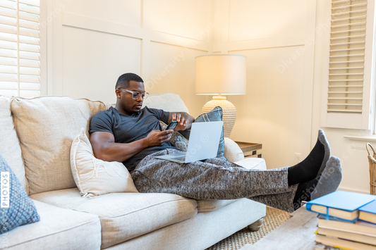 African American man working from home on laptop in living room, video chat conference call