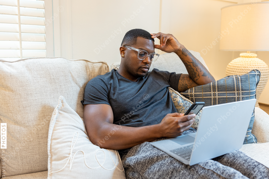 African American man working from home on laptop in living room, video chat conference call