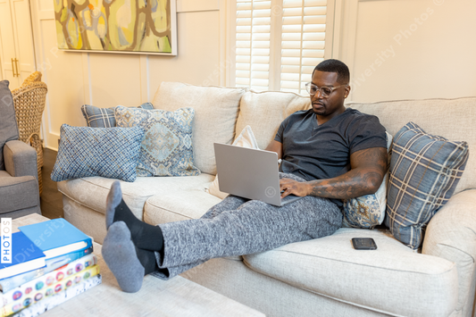 African American man working from home on laptop in living room, video chat conference call