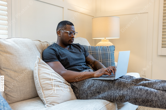 African American man working from home on laptop in living room, video chat conference call