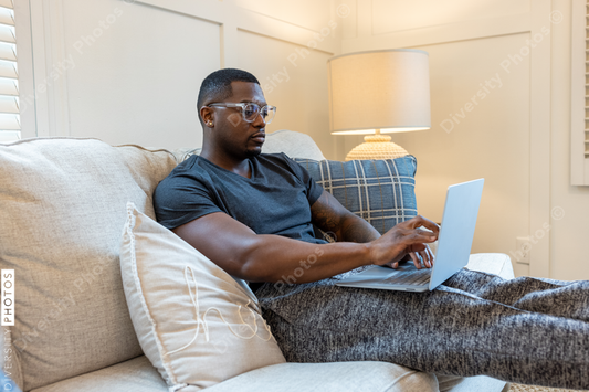 African American man working from home on laptop in living room, video chat conference call