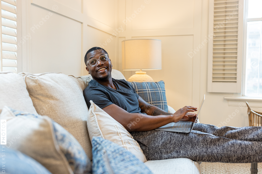African American man working from home on laptop in living room, video chat conference call