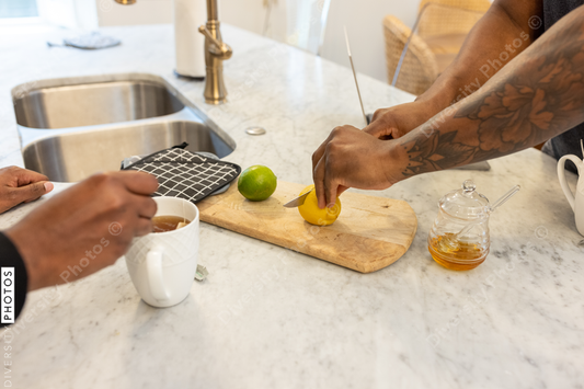 Black same sex couple drinking tea in kitchen at home