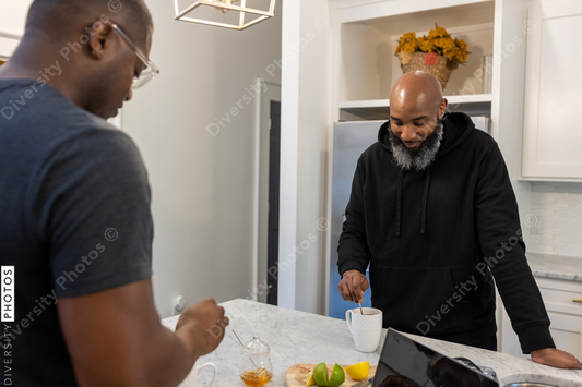 African American same sex couple talking in kitchen at home