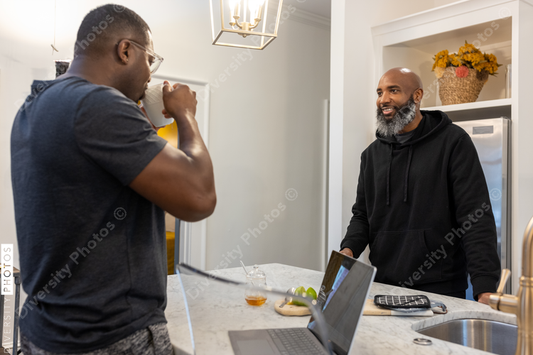 African American same sex couple talking in kitchen at home