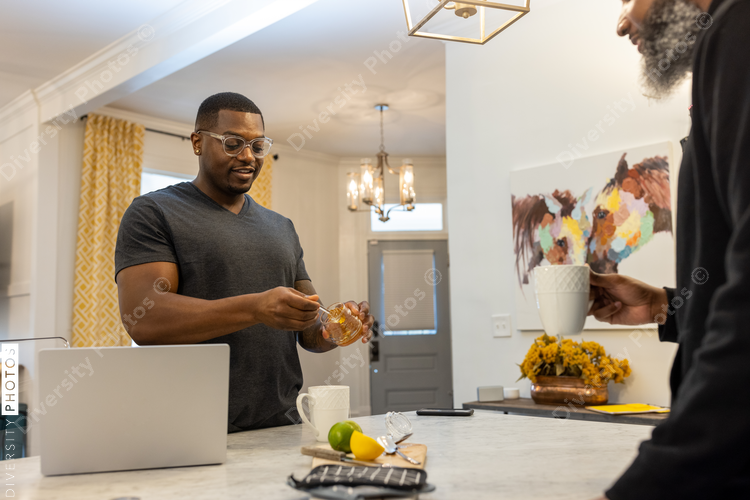 African American same sex couple talking in kitchen at home