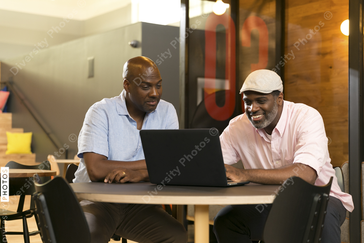 Smiling businessmen using laptop in office