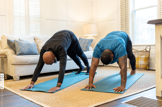 Black gay couple doing yoga exercises at home together, healthy lifestyle