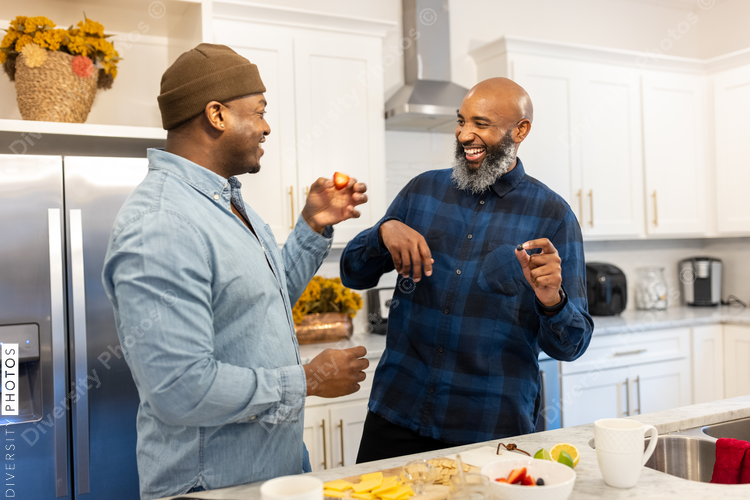 Gay couple, playful, cooking in the kitchen, loving moments