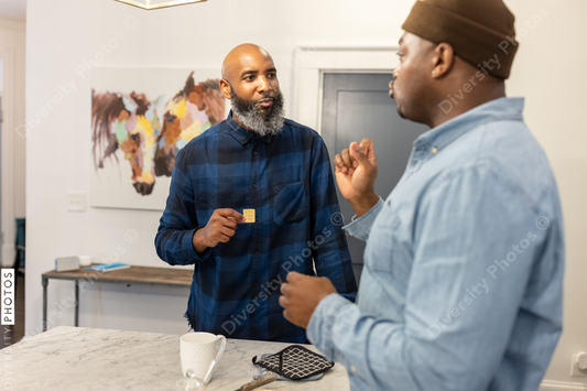 Black gay couple in kitchen at home, playful moment, conversations