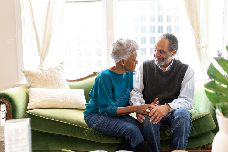 Senior African American couple sitting, smiling, on couch, connections
