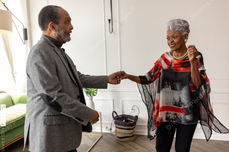 Smiling senior couple dancing at home, togetherness