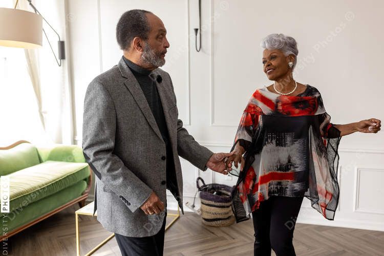 Smiling senior couple dancing at home, togetherness