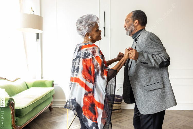 Smiling senior couple dancing at home, togetherness